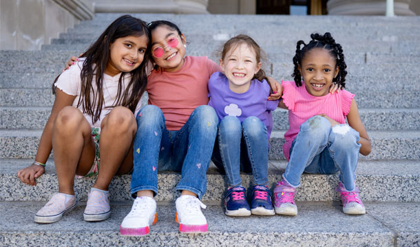 Six Girl Scouts of various ages sitting on a couch together